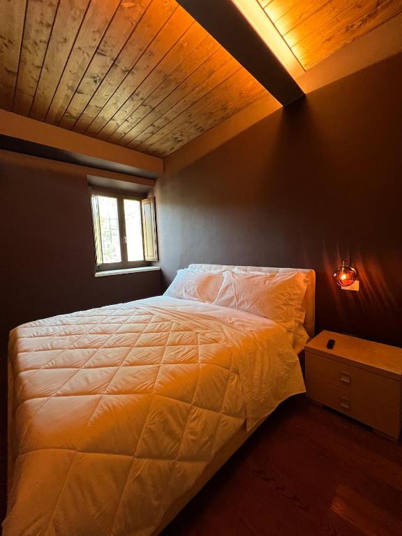 Camera da Letto: Intima e accogliente, con soffitto in legno e illuminazione soffusa, per garantirti il massimo del relax e del comfort.